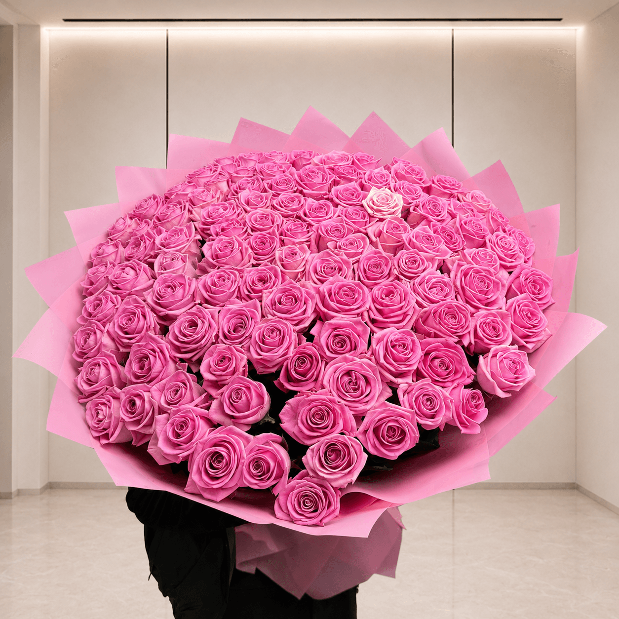 Большой букет из 101 розы Aqua в розовой упаковке на фоне офиса Start Flowers